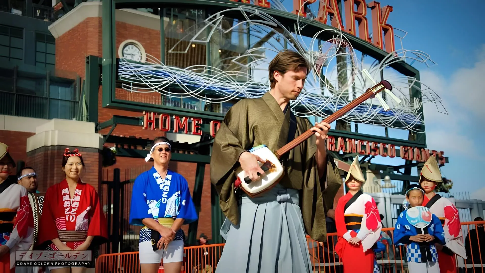 Kyle performing in hakama with dancers at an outdoor ballpark event