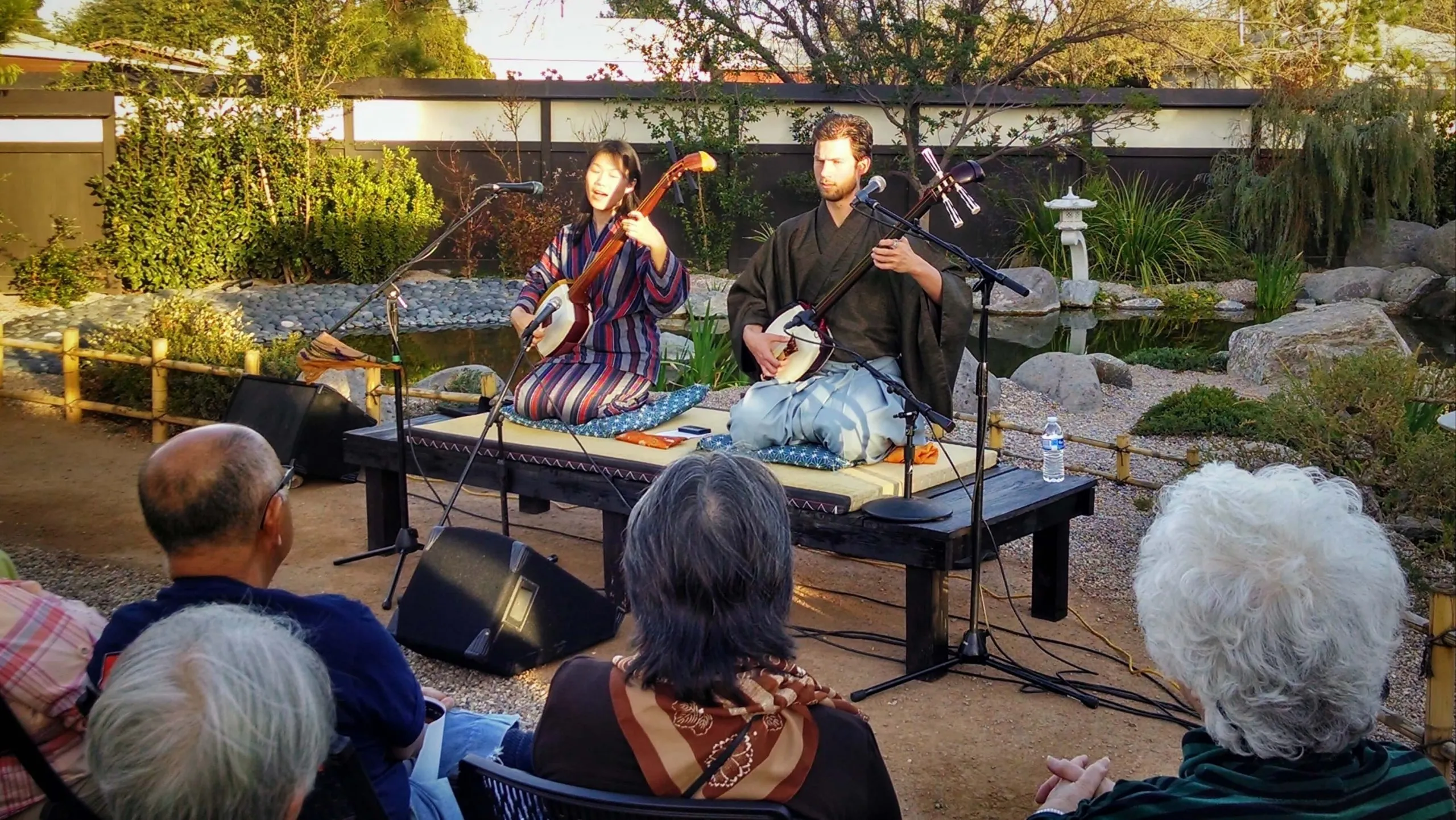 Kyle performing for an audience in a Japanese garden
