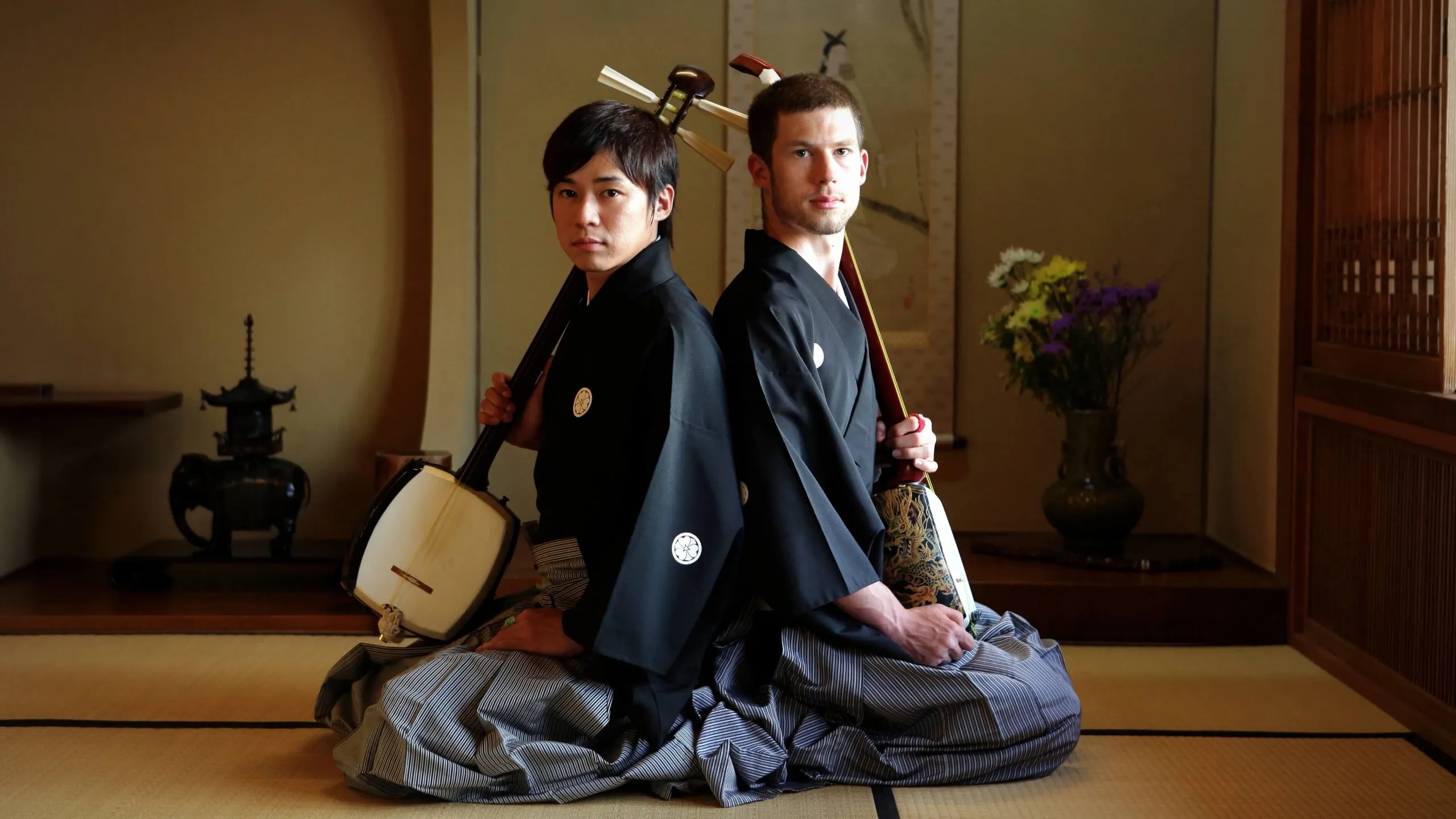Kyle and a fellow shamisen player in formal hakama in a tatami room