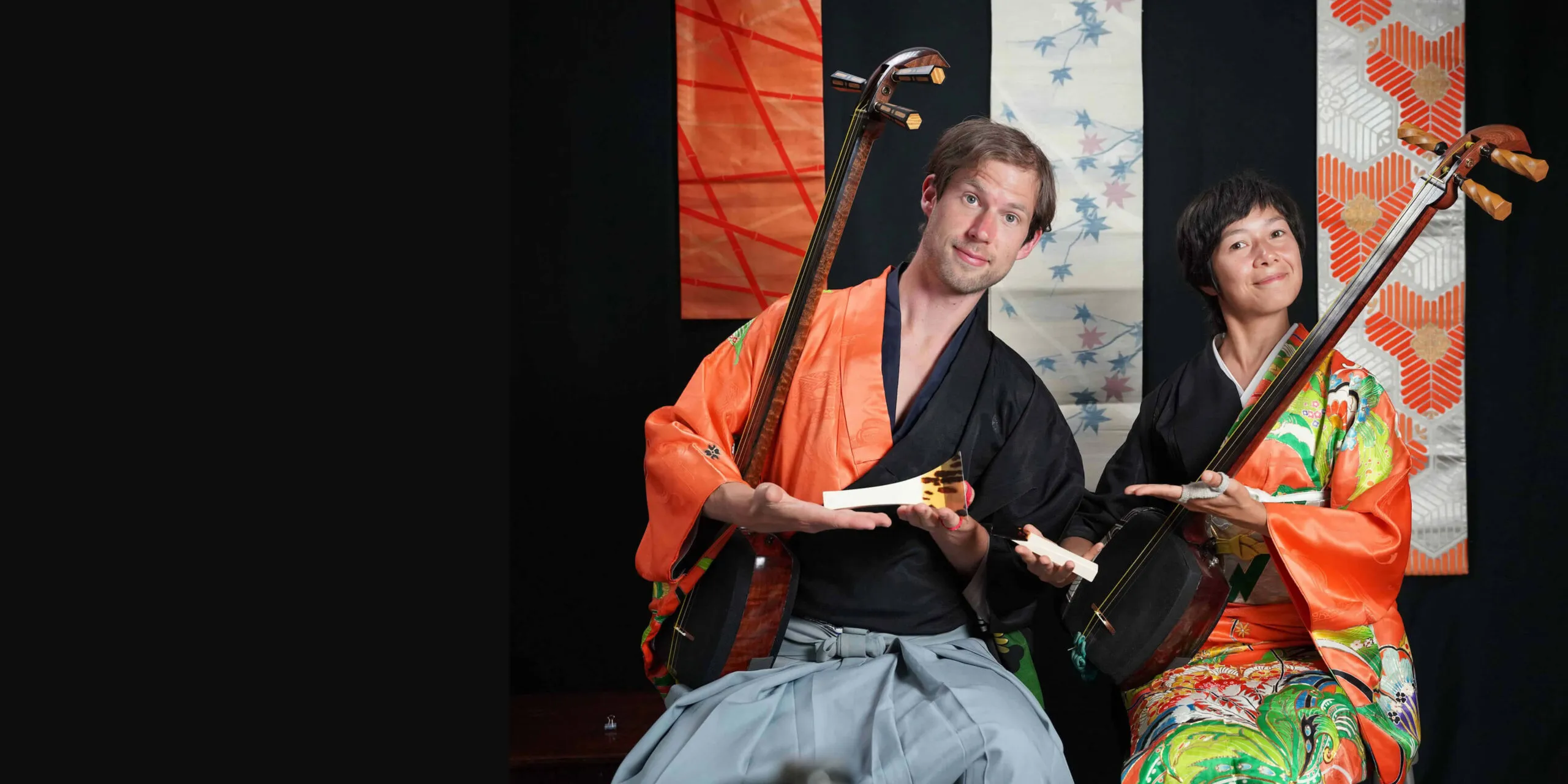 Kyle Abbott and Su Bunjamin of MK Fufu in kimono, each holding a Tsugaru shamisen